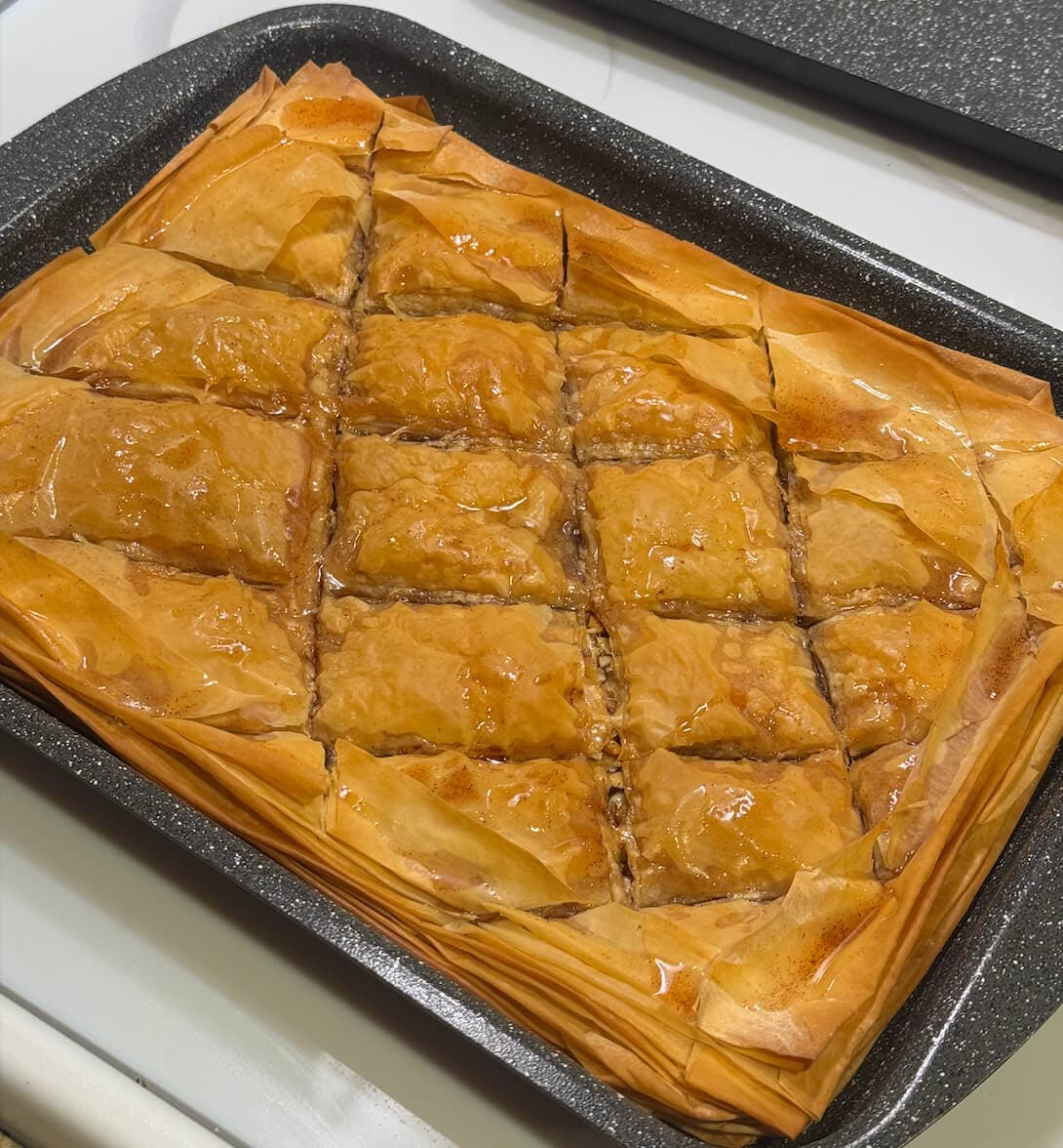 Vegan baklava with layered phyllo, nuts, cinnamon, and maple syrup glaze, a sweet and decadent dessert.