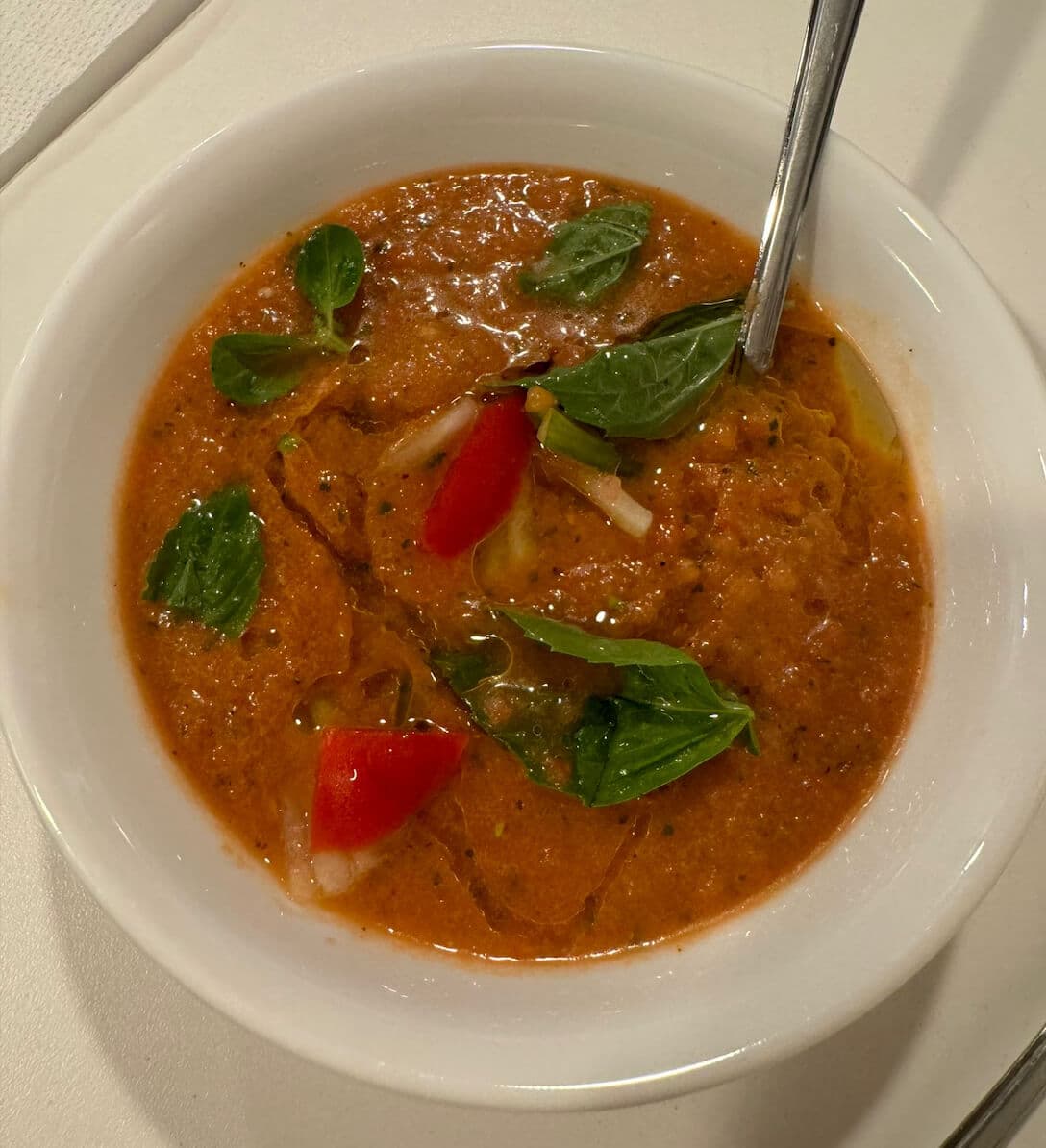 Vegan gazpacho made with fresh tomatoes, cucumber, pepper, onion, basil, olive oil, and vinegar, served chilled with optional toasted bread.