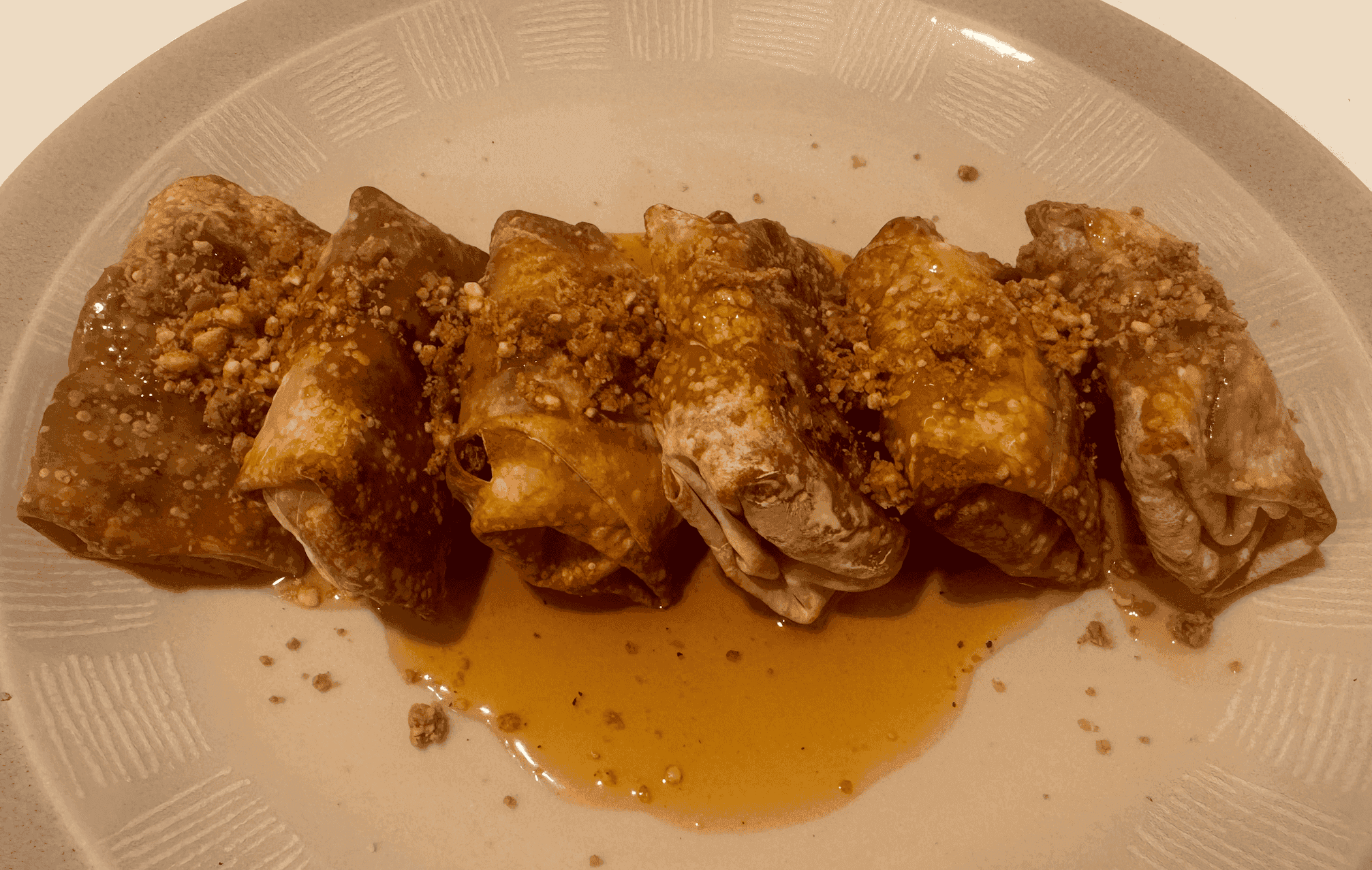 Crispy air fryer Biscoff baklava egg rolls filled with dates and cashews, lightly spiced with cinnamon and drizzled with maple syrup.